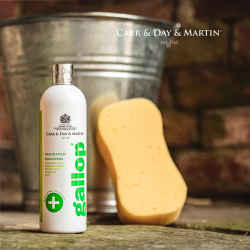 Image Bild: weiße Gallop Medizinisches Shampoo Produktflasche 500 ml mit grünfarbener Aufschrift steht auf dem Stallboden vor einem Blecheimer mit Schwamm.